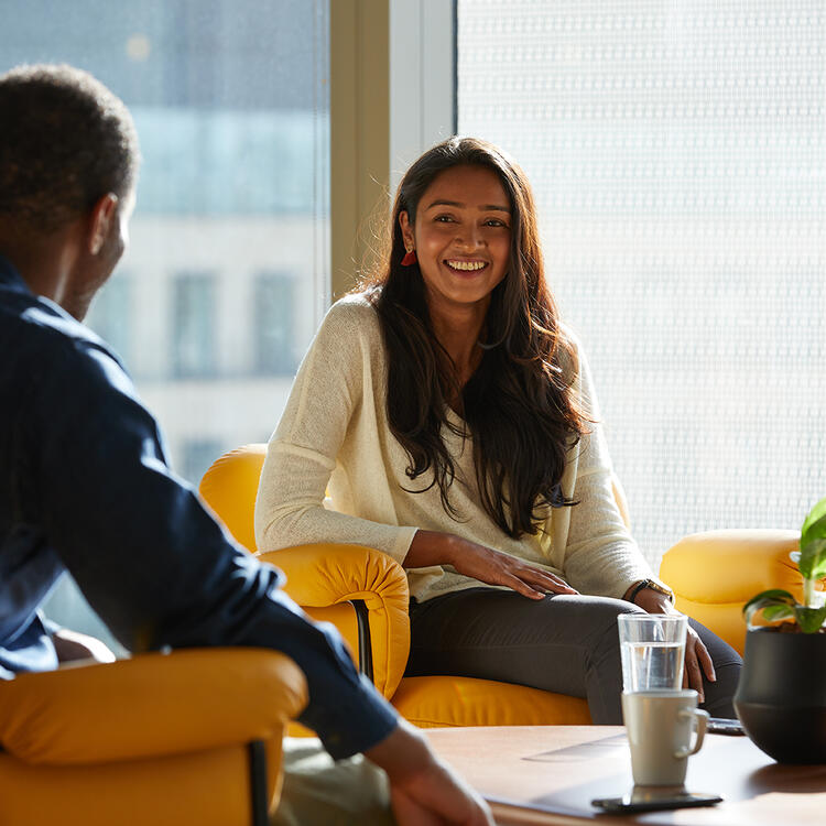 two people smiling at a ddesk in the sun